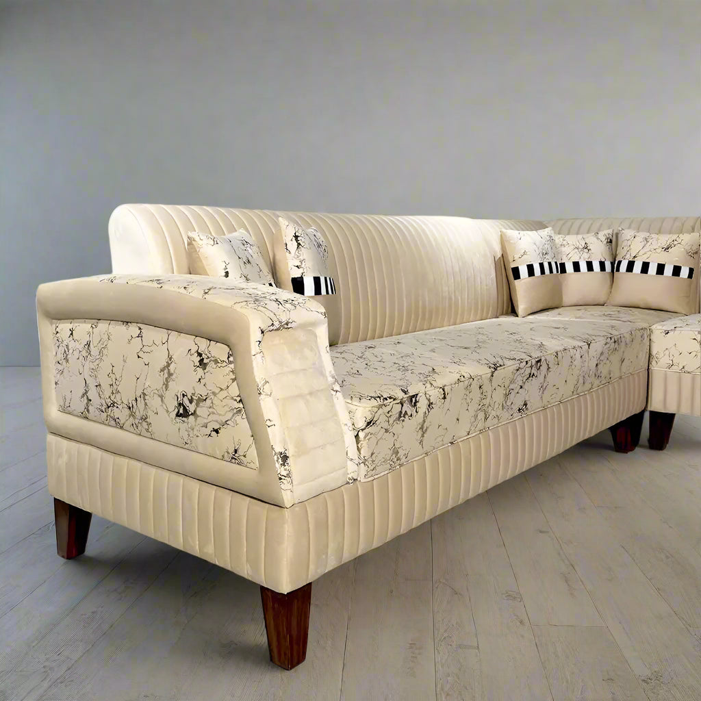Beige sectional sofa with floral-patterned cushions on a marble floor, featuring Lahore Furniture logo.