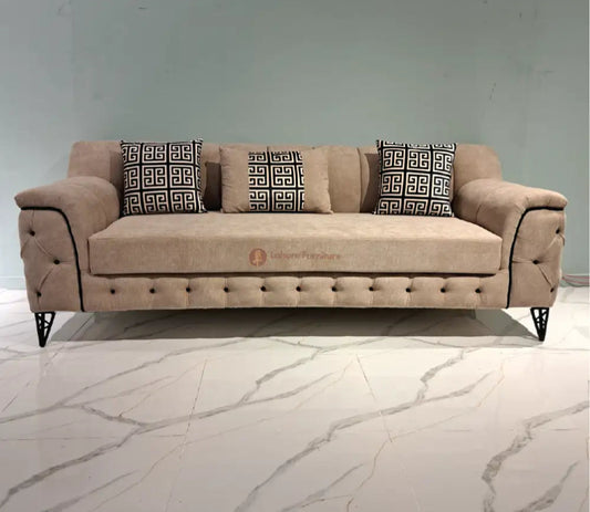 Beige sofa with patterned cushions on a marble floor, branded 'Lahore Furniture'.
